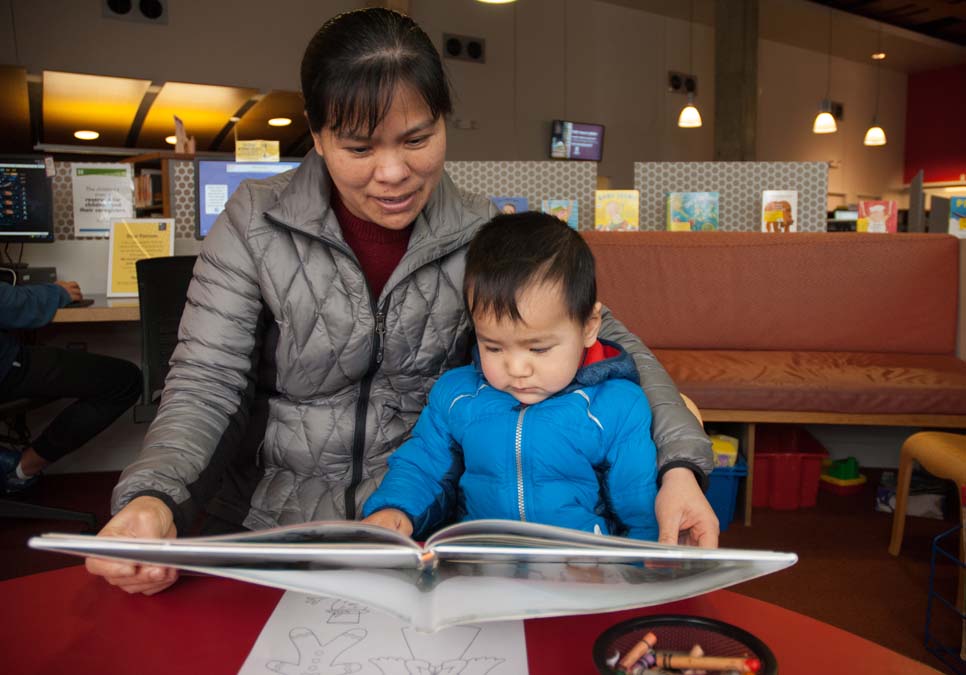 Family reading in the children’s area at the International District/Chinatown Branch