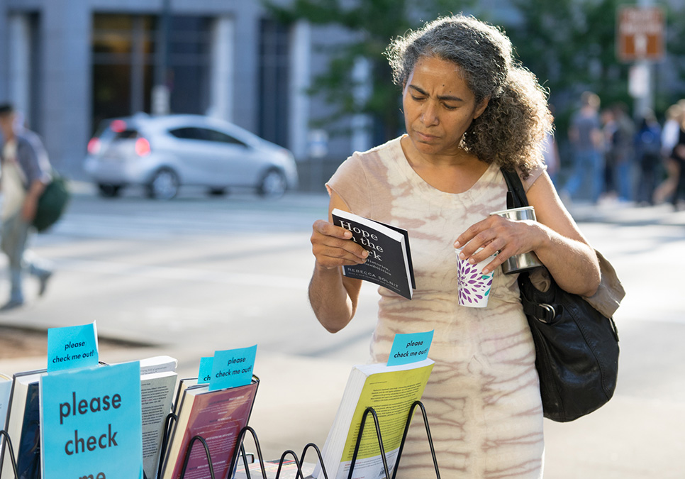 Patron looking at book at Art on the Plaza event at the Central Library in 2018
