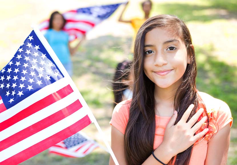 young girl next to american flag